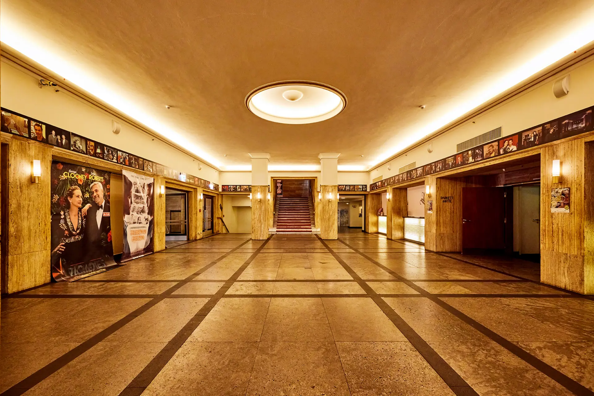Eingangshalle der Lichtburg in Essen mit modernem Deckendesign und nostalgischen Filmplakaten.