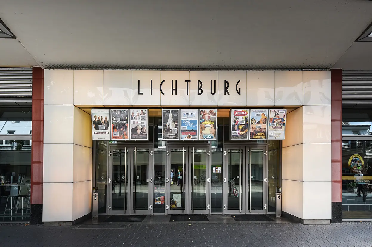 Eingang der Lichtburg, einem bekannten Kino mit fünf doppelflügeligen Glastüren und Filmplakaten.