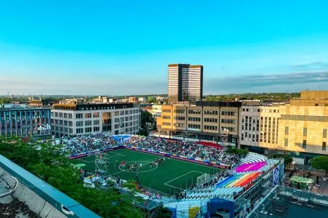 Fußballfeld mit vollen Zuschauertribünen auf dem Kennedyplatz, von oben gesehen
