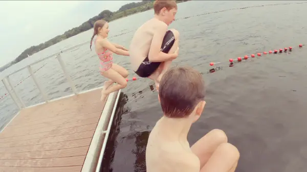 Kinder springen von einem Steg in den Baldeneysee