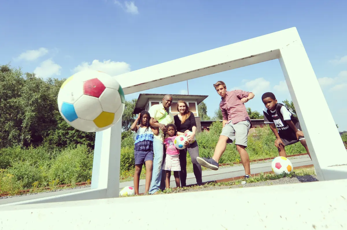Familie beim Soccergolf vor einem großen Rahmen mit Fußball auf Zollverein