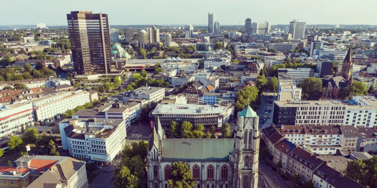 Luftbild der Essener Innenstadt: im Vordergrund die Kreuzeskirche, dahinter die Hochhäuser der City