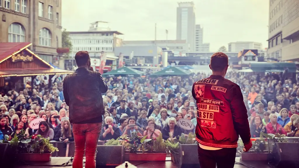 Zwei Musiker auf einer Bühne blicken auf das dicht gedrängte Publikum in der Innenstadt