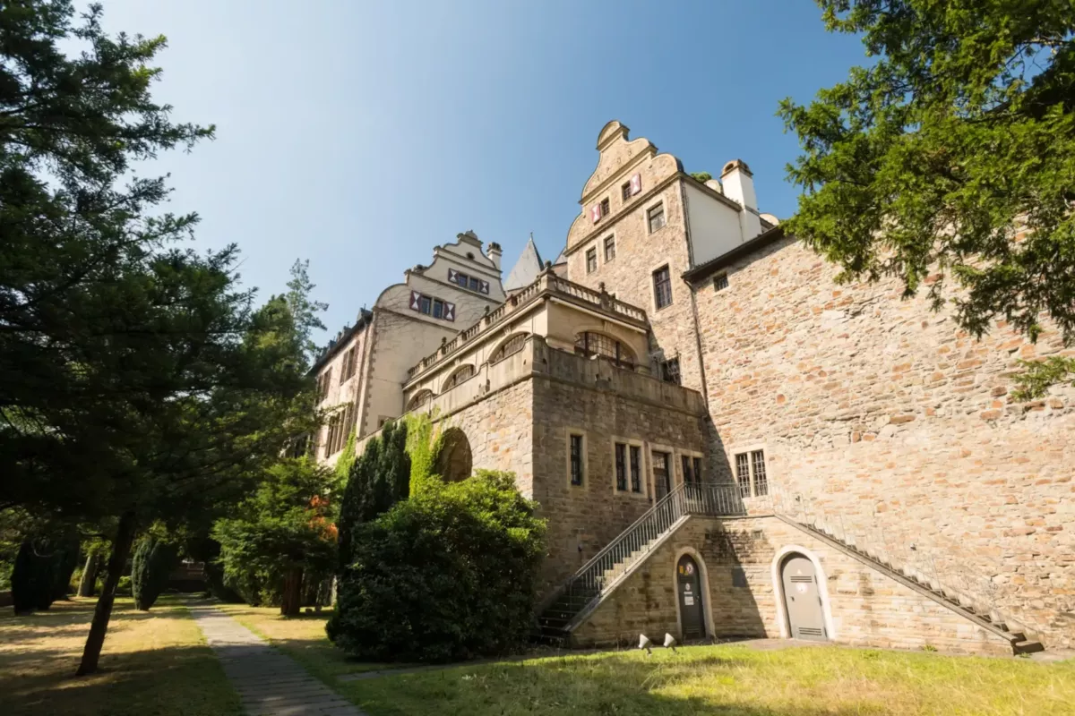 Schloss Landsberg mit Natursteinfassade, Freitreppe und Bäumen im Sonnenlicht
