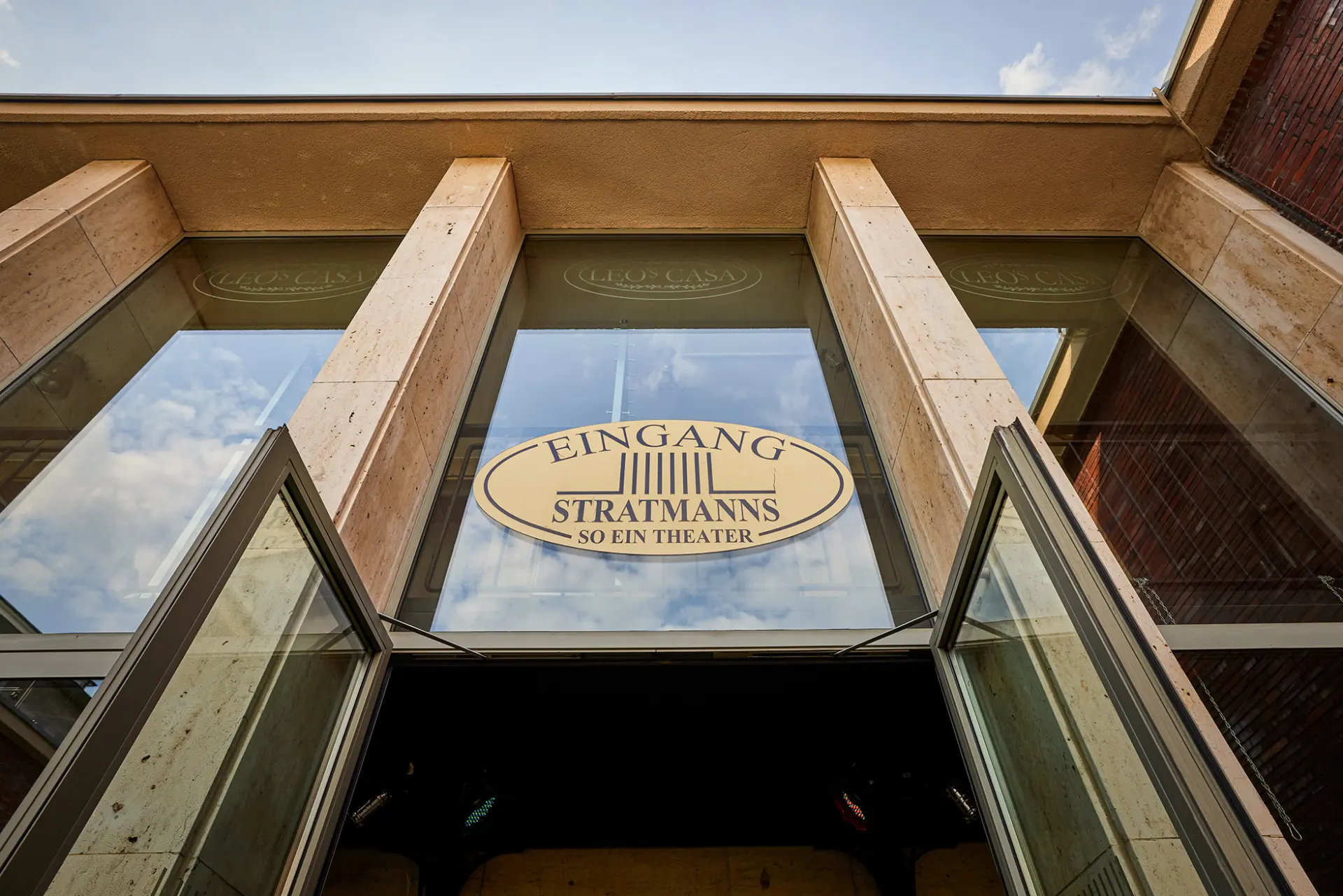 Glasfassade des Stratmanns Theaters in Essen mit ovalem Schild: "Eingang Stratmanns, so ein Theater".