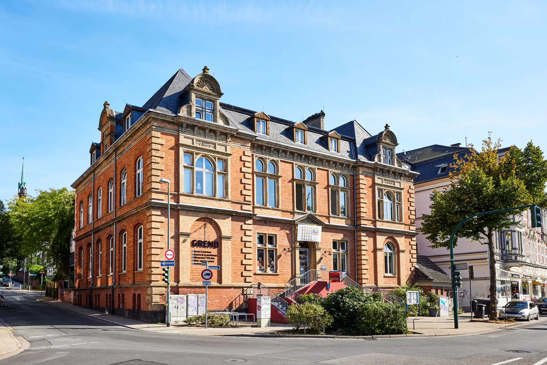 Historisches Backsteingebäude in Essen, mit Giebeln und blauen Fenstern, sonniger Herbsttag.