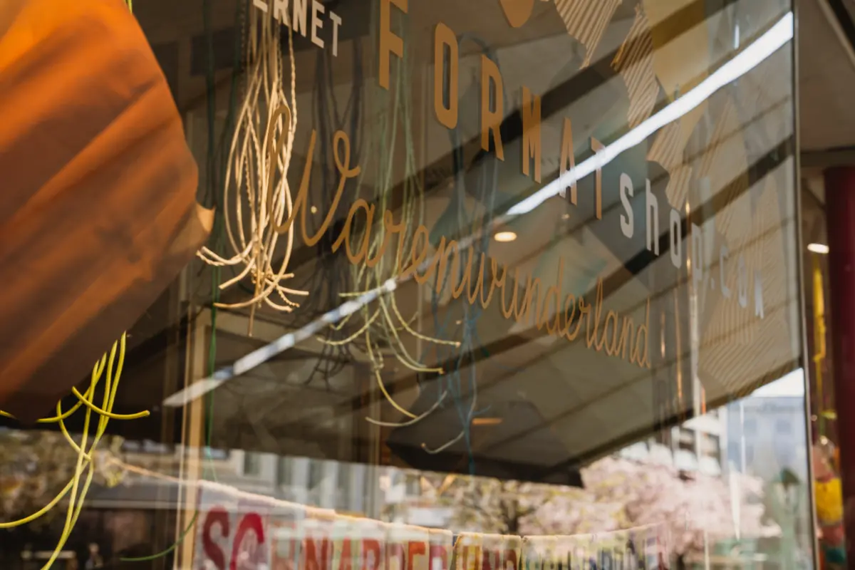 Schaufenster mit der Aufschrift "Internet Format Shop" und "Warenwunderland", im Hintergrund Bäume.
