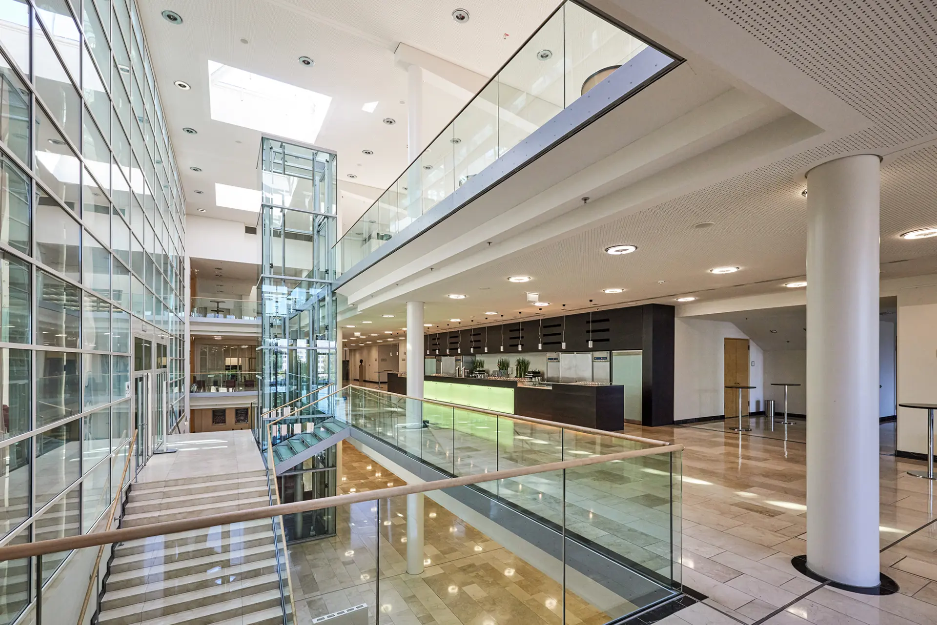 Modernes Interieur der Philharmonie Essen mit Glasfassaden und Marmorfußboden, offenes Foyer.