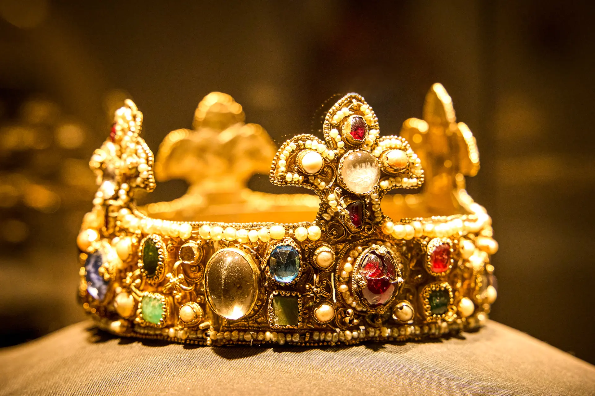 Goldene Krone verziert mit Edelsteinen und Perlen, reich detailliert und kunstvoll gestaltet.