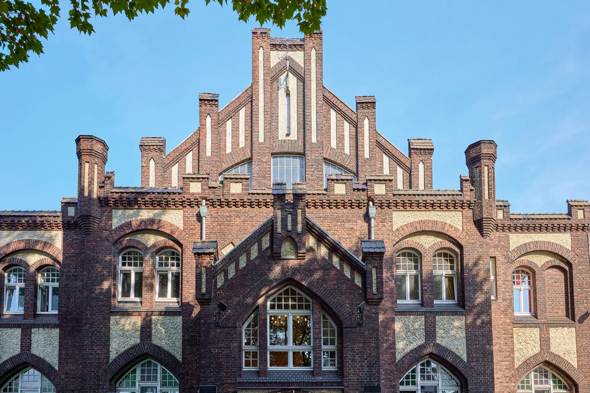 Historisches Gebäude in Essen mit detaillierter neo-gotischer Backsteinfassade und großen Fenstern.