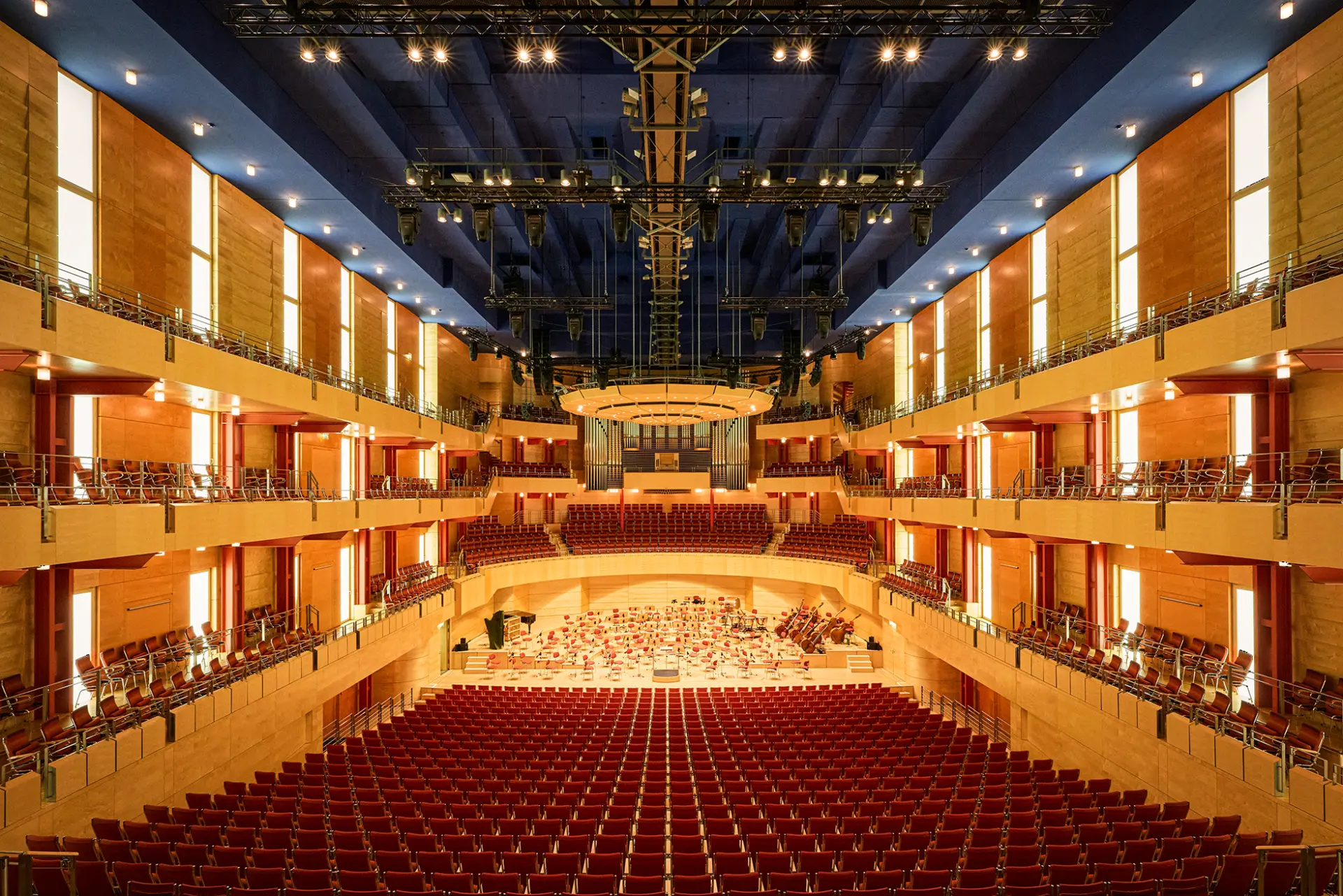 Innenansicht der Philharmonie Essen mit leeren roten Sitzen und prächtiger beleuchteter Bühne.