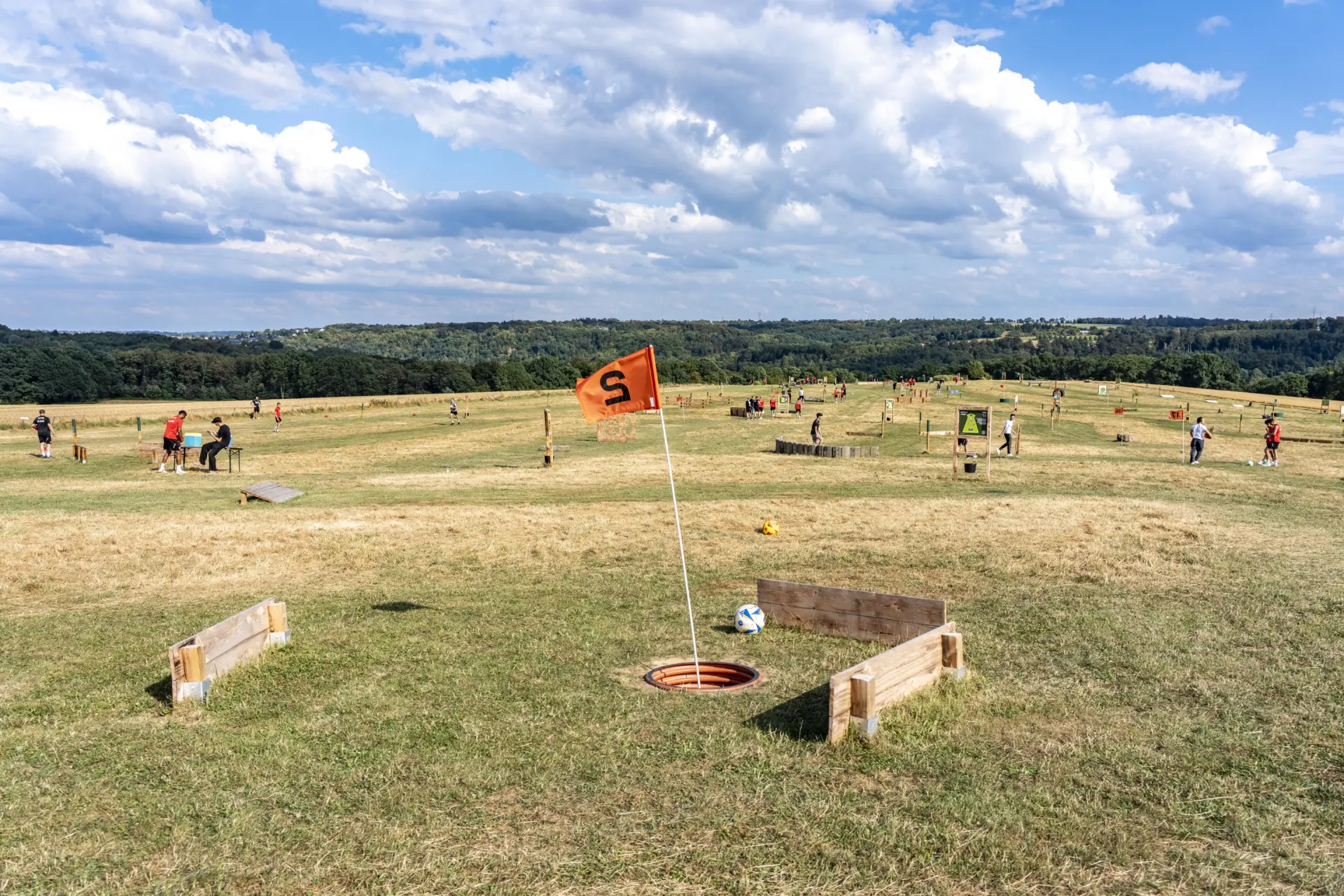 Fußballgolf-Anlage auf einer Wiese in Essen mit orangefarbener Fahne und weitem Blick.
