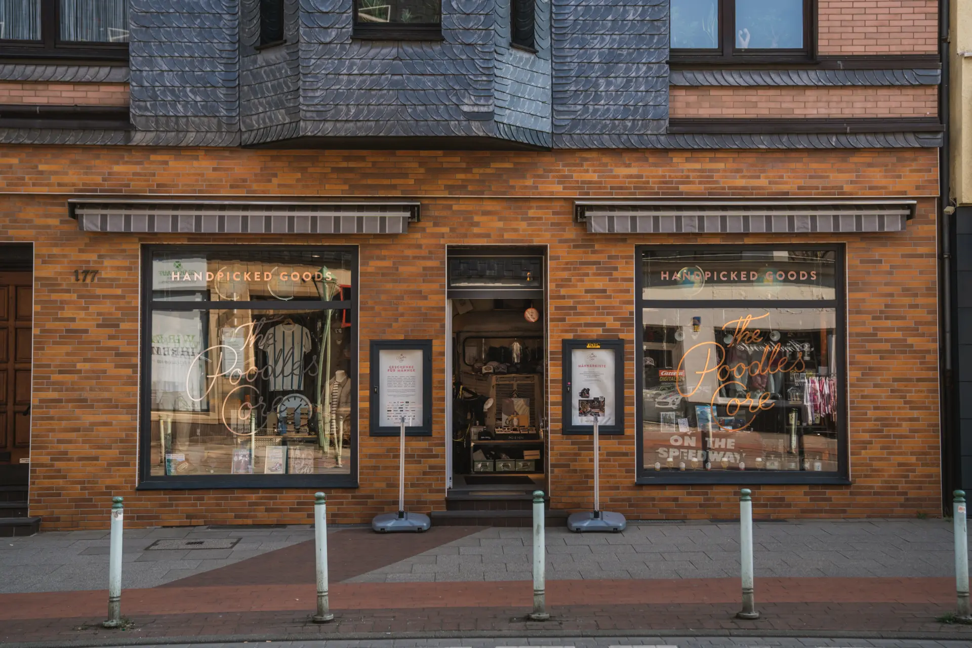Fassade eines Geschäfts mit auffälliger orange-brauner Ziegelfassade und großen Schaufenstern.