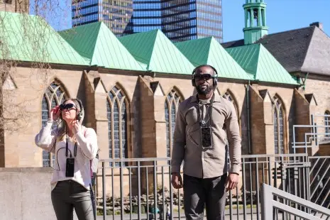 Zwei Personen bei der Mixed-Reality Tour vor dem Essener Dom
